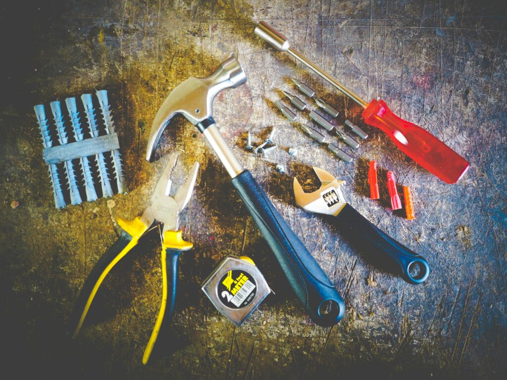 Collection of hand tools including hammer, screwdriver, and pliers in a workshop setting. service in Conroe Texas and Montgomery County