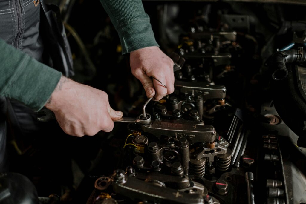 Close-up of a mechanic using hand tools to fix an engine, showcasing precision and skill. service in Conroe Texas and Montgomery County